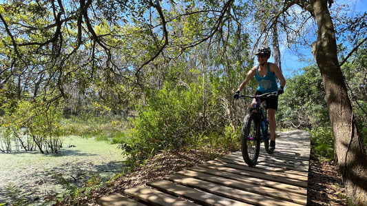 Riding on a wooden bridge wearing the Bike Part Mandala Tank